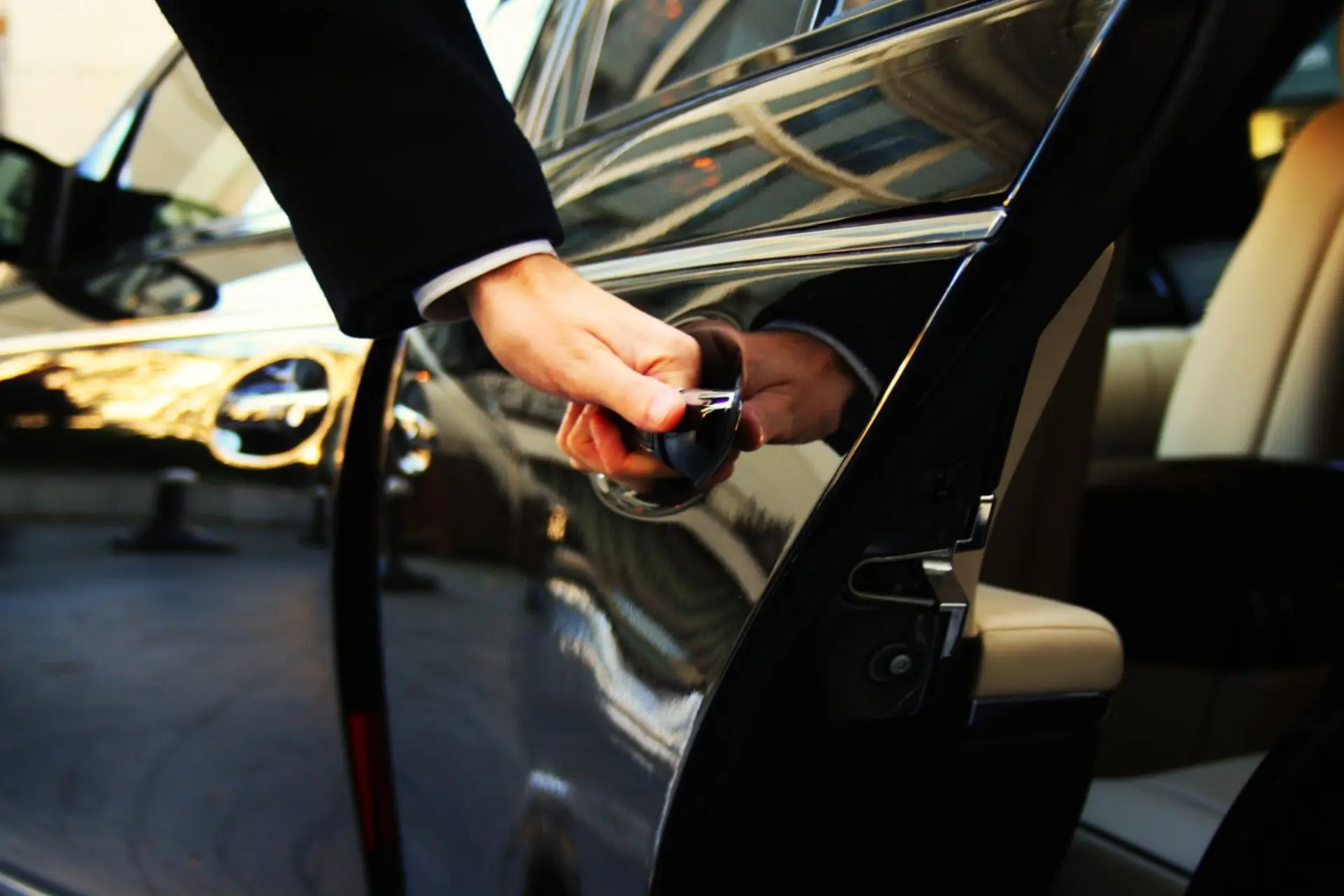 Tony opening the door of a luxury SUV from the fleet — Boca Raton Airport Car Service FLL, PBI & MIA airport transfers
